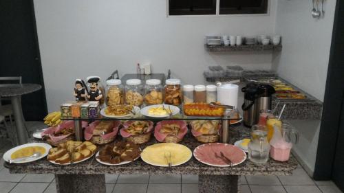 a table with a bunch of food on it at Alameda Hotel Centro in Garanhuns