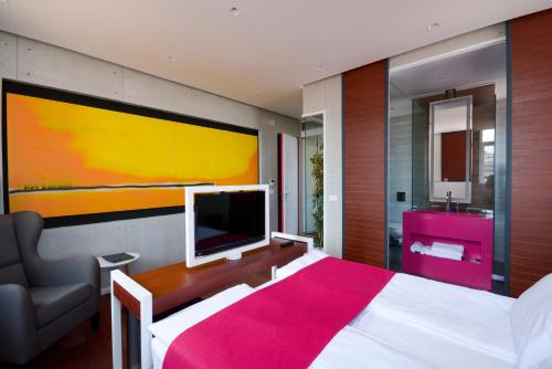 a bedroom with a large bed and a television at Boutique Rooms in Belgrade