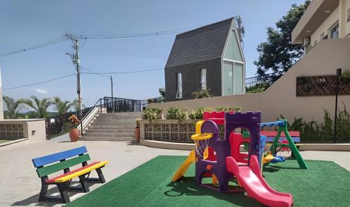 um parque infantil com equipamento colorido em frente a uma casa em Apto com Garagem e Wi-Fi a 4 minutos da Canção Nova em Cachoeira Paulista