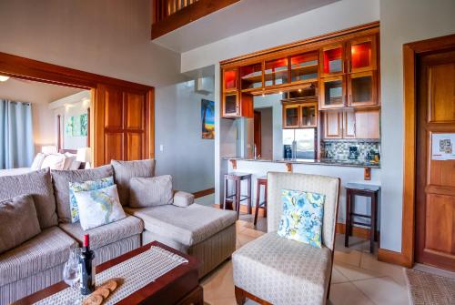 a living room with a couch and a kitchen at The Villas at Cocoplum in Placencia Village