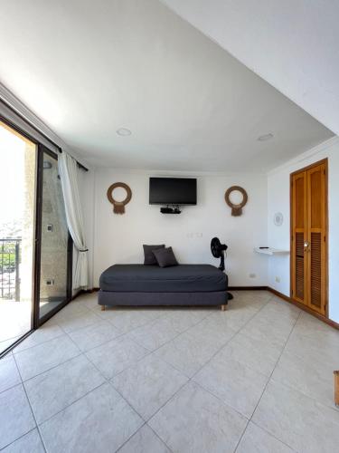 a bedroom with a bed and a tv on the wall at Edificio El Peñon del Rodadero Apartamento Playa Rodadero in Santa Marta