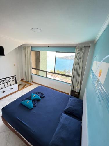a large bed in a room with a large window at Edificio El Peñon del Rodadero Apartamento Playa Rodadero in Santa Marta
