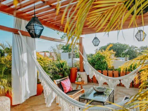 a hammock on a patio with plants at Le Muuch Hotel Boutique in Valladolid