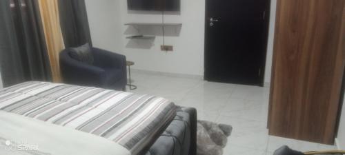 een woonkamer met een bank en een stoel bij George's property in Accra