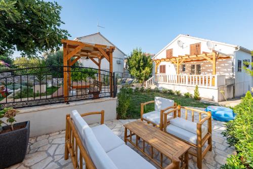a patio with a couch and a table and chairs at Home with a unique view in Preko