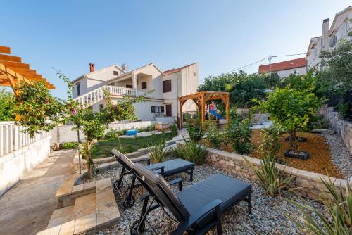 a patio with a table and chairs in a garden at Home with a unique view in Preko