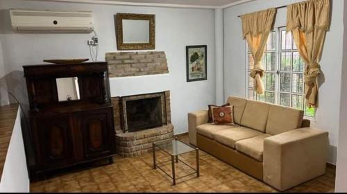 ein Wohnzimmer mit einem Sofa und einem Kamin in der Unterkunft Emy in Oberá