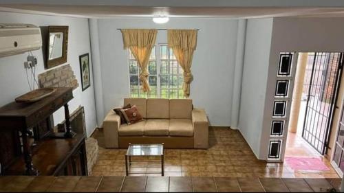 uma sala de estar com um sofá e um piano em Emy em Oberá