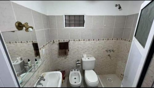 uma casa de banho com um lavatório, um WC e um lavatório. em Emy em Oberá