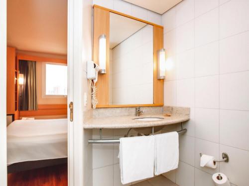 a bathroom with a sink and a mirror at ibis Belo Horizonte Savassi in Belo Horizonte