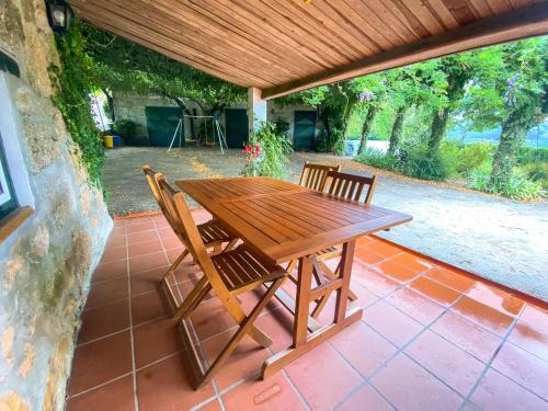 a wooden table and chairs on a patio at Casa do Crasto in Amarante