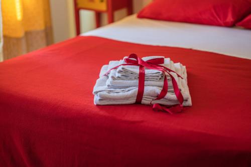 a stack of towels tied with a red ribbon on a bed at Settecentoalberi Agriturismo in Noventa di Piave