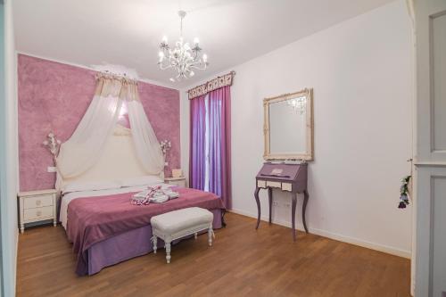 a pink and white bedroom with a bed and a mirror at Settecentoalberi Agriturismo in Noventa di Piave
