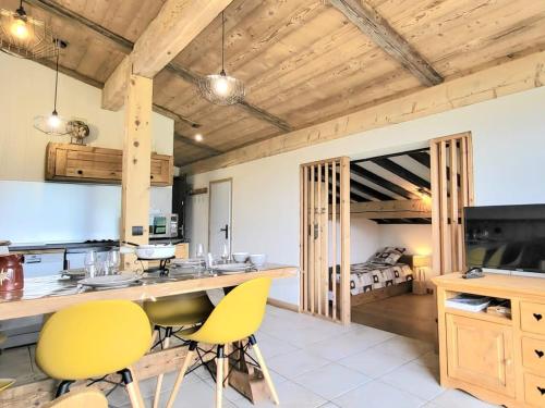 une cuisine avec des chaises jaunes et une chambre avec un lit dans l'établissement Appartement calme près des pistes, rénové, 2 chambres, parking non privatif - FR-1-505-86, à Notre-Dame-de-Bellecombe