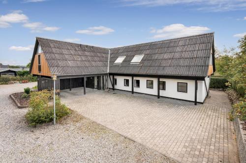 a large white house with a black roof at 9 Rooms Amazing Sommerhouse in Børkop