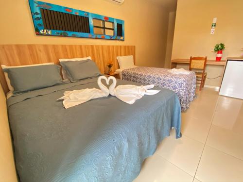 a bed with a bow on it in a room at Tamandaré Praia Hotel in Tamandaré