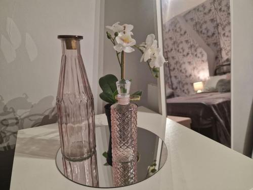 a glass bottle and a vase on a table at 4 bed charming, Family-friendly cottage 1694 in Rossendale