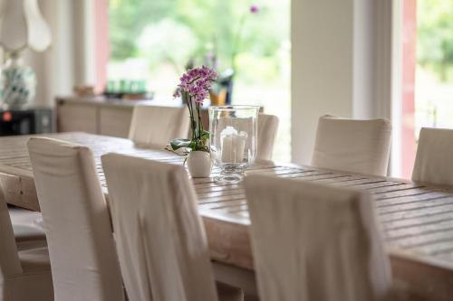 a wooden table with chairs and a vase of flowers on it at Settecentoalberi Agriturismo in Noventa di Piave