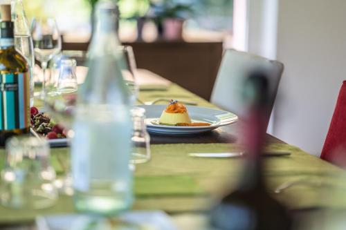 a table with a plate of food and a bottle of wine at Settecentoalberi Agriturismo in Noventa di Piave