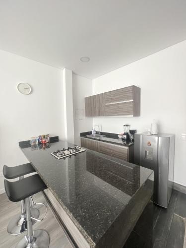 a kitchen with a black counter top and a stove at Edificio Lotus Loft in Cali