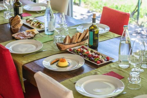 a table with plates of food and bottles of wine at Settecentoalberi Agriturismo in Noventa di Piave