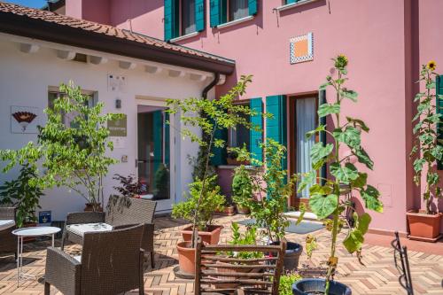 a patio with plants and chairs in front of a building at Settecentoalberi Agriturismo in Noventa di Piave