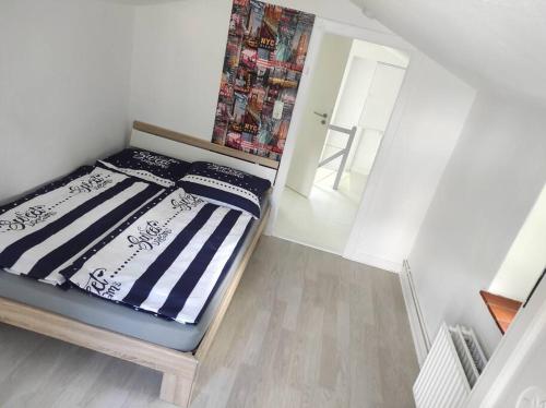 Ferienhaus Bieberhöhe في بلون: غرفة نوم صغيرة مع سرير بملاءات مخططة