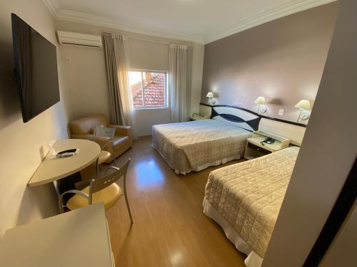 Habitación de hotel con 2 camas y mesa en Hotel Maerkli en Santo Ângelo