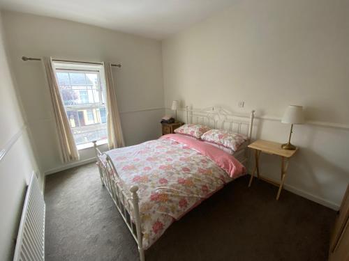 a white bedroom with a bed and a window at Irvinestown Fermanagh 2 Bedroom Apartment in Irvinestown
