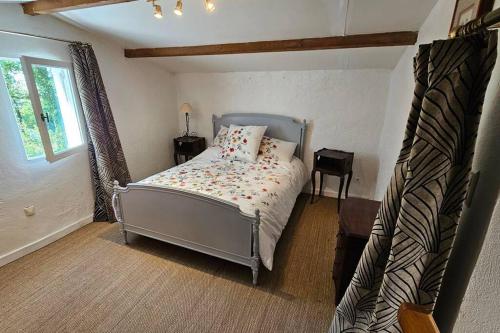 a small bedroom with a bed and a window at Mazet (maisonnette provençale) in Saint-Cézaire-sur-Siagne
