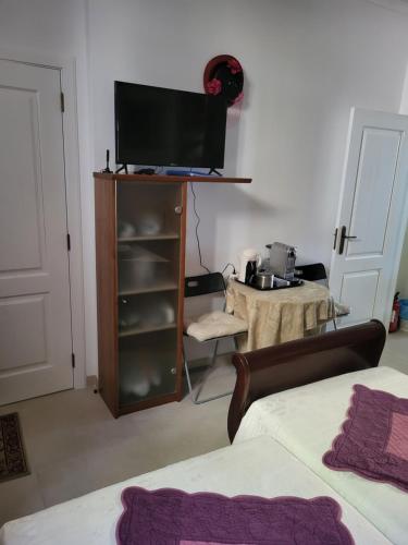a room with two beds and a television on a cabinet at Sintra lousa in Sintra