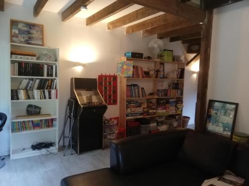 uma sala de estar com um sofá e prateleiras de livros em Grande maison au calme au cœur d un bois em Ferrières