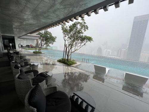 a table and chairs with a view of a pool at The Axon Suites Bukit Bintang By Cozy Stay in Kuala Lumpur