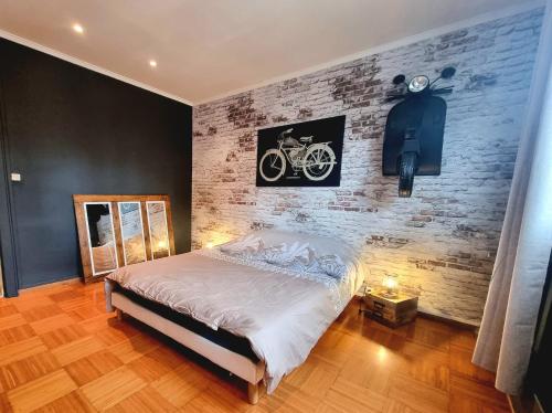 una camera con letto e muro di mattoni di Le Garage a Lens