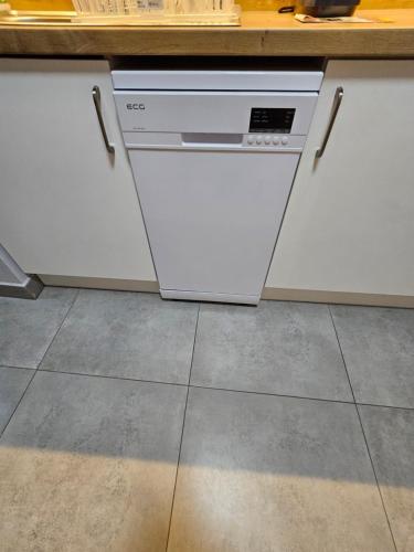 a kitchen with white cabinets and a dishwasher at Apartmány Formanka na náměstí in Hustopeče