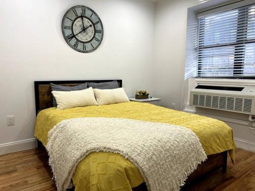 a bedroom with a bed with a clock on the wall at Cozy Modern Brooklyn Apartment w/ Balcony in Brooklyn