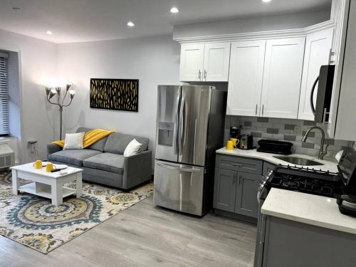 a kitchen and living room with a couch and a refrigerator at Cozy Modern Brooklyn Apartment w/ Balcony in Brooklyn