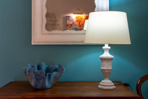 a lamp sitting on a table next to a mirror at Sa Finqueta, Luxury Elegant Mansion with breathtaking views of Soller in Sóller