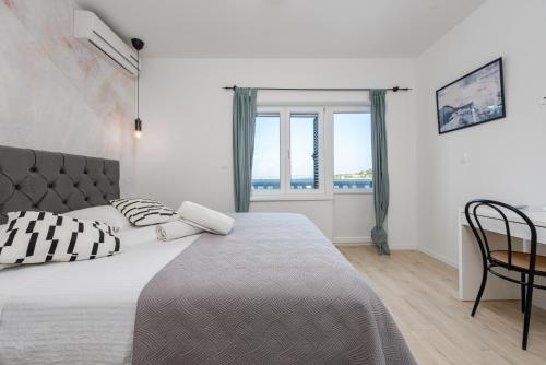 een slaapkamer met een bed, een tafel en een raam bij Home with a unique view in Preko