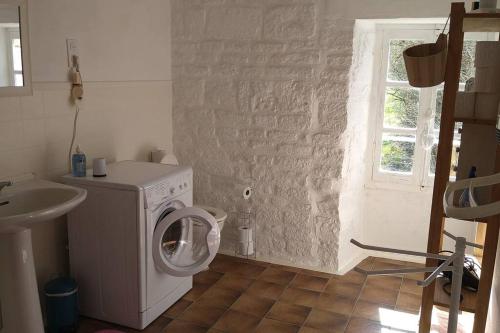 y baño con lavadora y lavamanos. en Le Moulin de la Borie en Belfort-du-Quercy