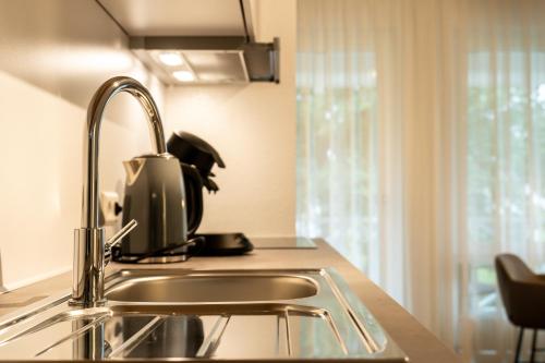 a kitchen with a sink and a microwave at Kapfwald Appartements in Bad Dürrheim