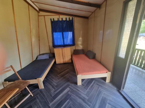 an inside view of a tiny house with a bed and a chair at Chatky Kempík in Olbramkostel