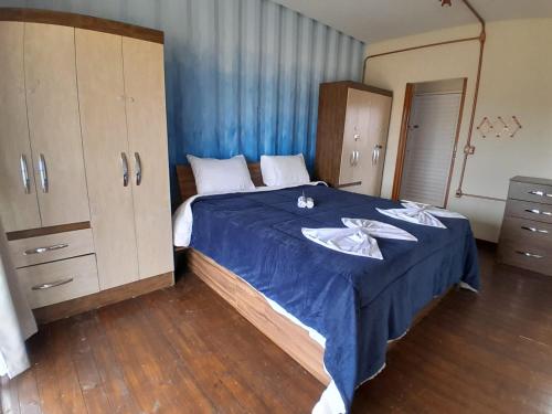 een slaapkamer met een groot bed en een blauwe deken bij Casa Topázio no Container dos Cristais in Delfinópolis