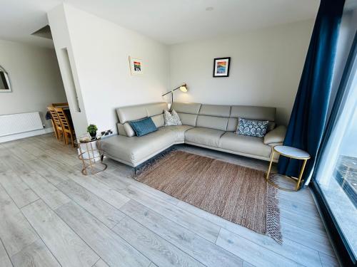 a living room with a couch and a large window at Beside the sea & minutes from Cliffs-Clahane Shore Lodge in Liscannor