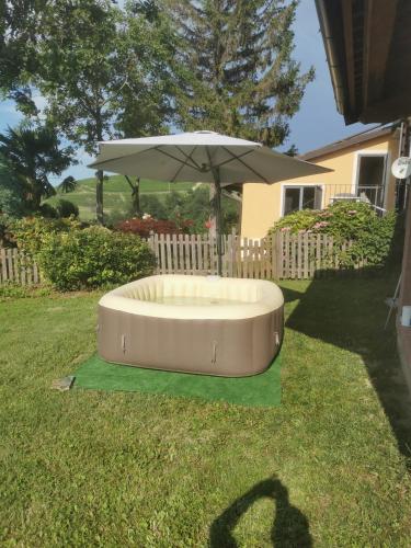 a large umbrella sitting in the grass in a yard at Splendido rustico nella Langa in Clavesana