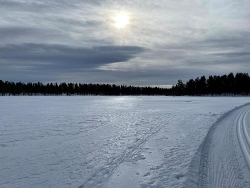 a snow covered field with the sun in the sky at Fryksås Hotell & Gestgifveri in Fryksås