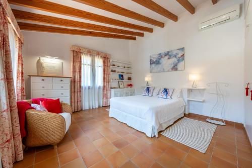 a bedroom with a white bed and a chair at Sa Finqueta, Luxury Elegant Mansion with breathtaking views of Soller in Sóller