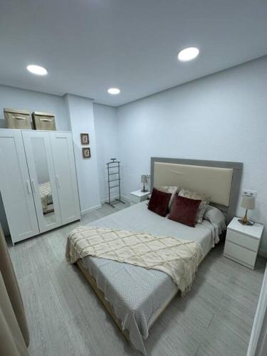 1 dormitorio con 1 cama grande y armarios blancos en Apartamento puestas de sol, en Chiclana de la Frontera