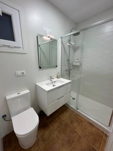 a bathroom with a toilet and a sink and a shower at Apartamento puestas de sol in Chiclana de la Frontera