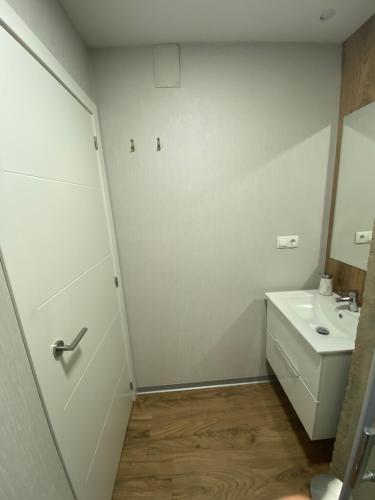 łazienka z umywalką, toaletą i drzwiami w obiekcie Apartamento Turístico Campo de la Verdad w Kordobie